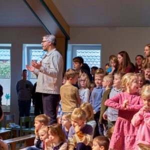 Pastor Thilo Kierner und Kinder beten auf der Bühne