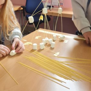 Kinder bauen aus Marshmellows und Spaghetti einen Turm