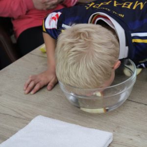 Kind beim Apfeltauchen